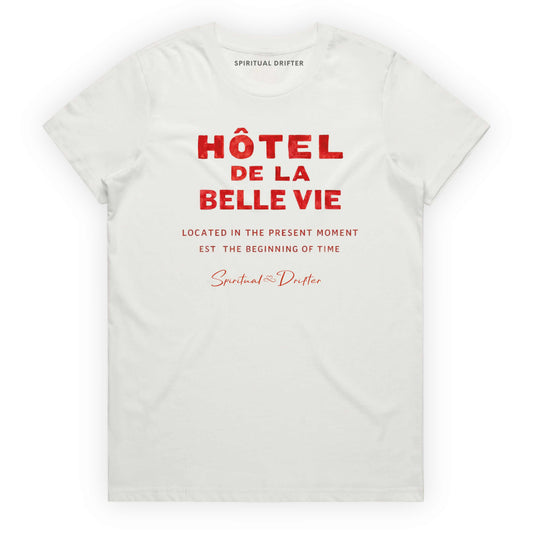 White Spiritual Drifter t-shirt with red text 'Hôtel de la Belle Vie' on a white background. Conscious clothing for awakened souls.
