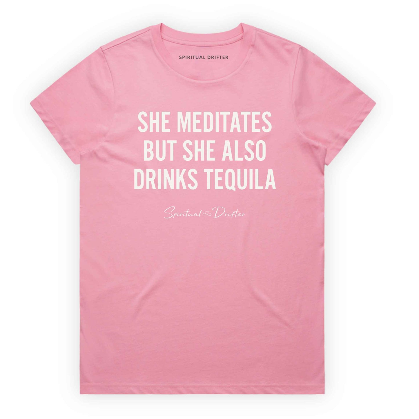 Bubblegum Pink Soft Pink Spiritual Drifter t-shirt with white text 'SHE MEDITATES BUT SHE ALSO DRINKS TEQUILA' on a white background. Women's spiritual graphic tee. Relaxed beach lifestyle fashion for meditation lovers, yoga enthusiasts, wellness travelers, and free-spirited women. Meditation and yoga clothing for awakened souls.