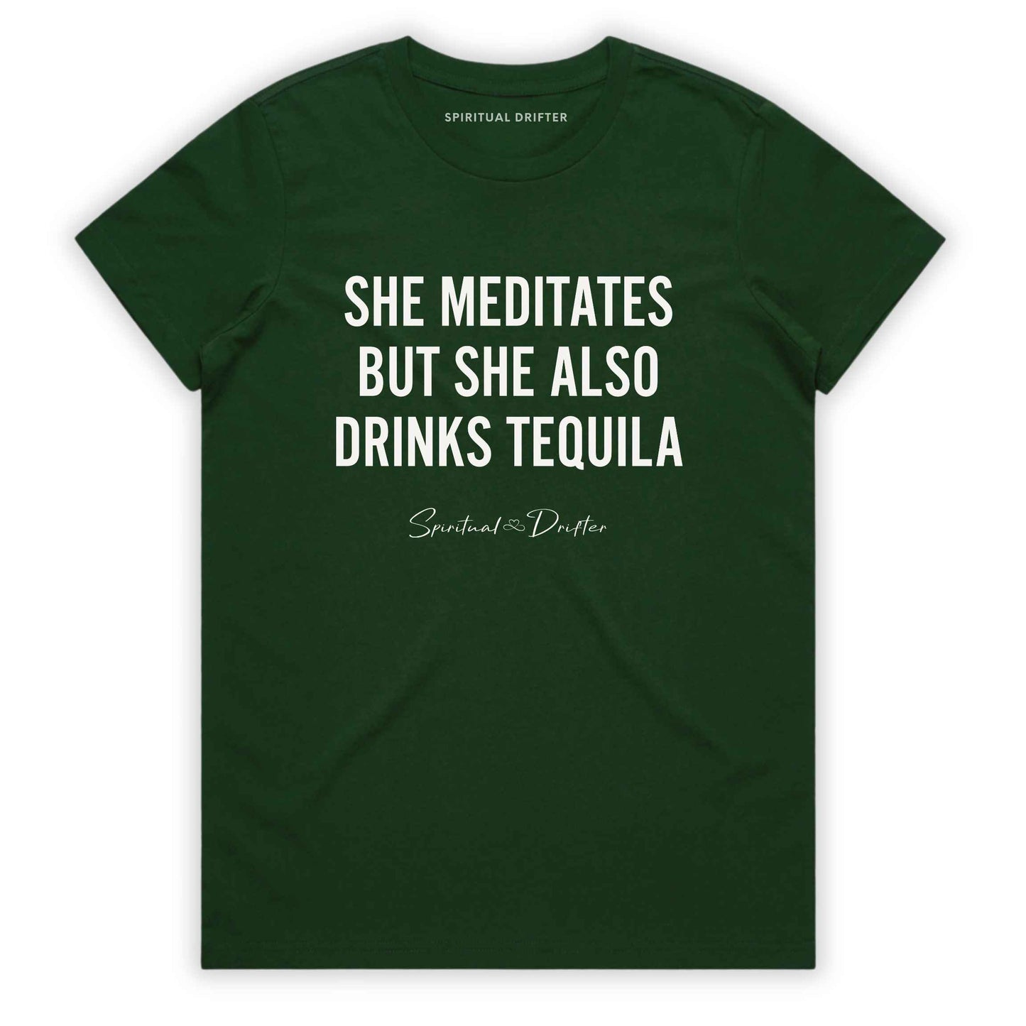Forest Green Spiritual Drifter t-shirt with white text 'SHE MEDITATES BUT SHE ALSO DRINKS TEQUILA' on a white background. Women's spiritual graphic tee. Relaxed beach lifestyle fashion for meditation lovers, yoga enthusiasts, wellness travelers, and free-spirited women. Meditation and yoga clothing for awakened souls.