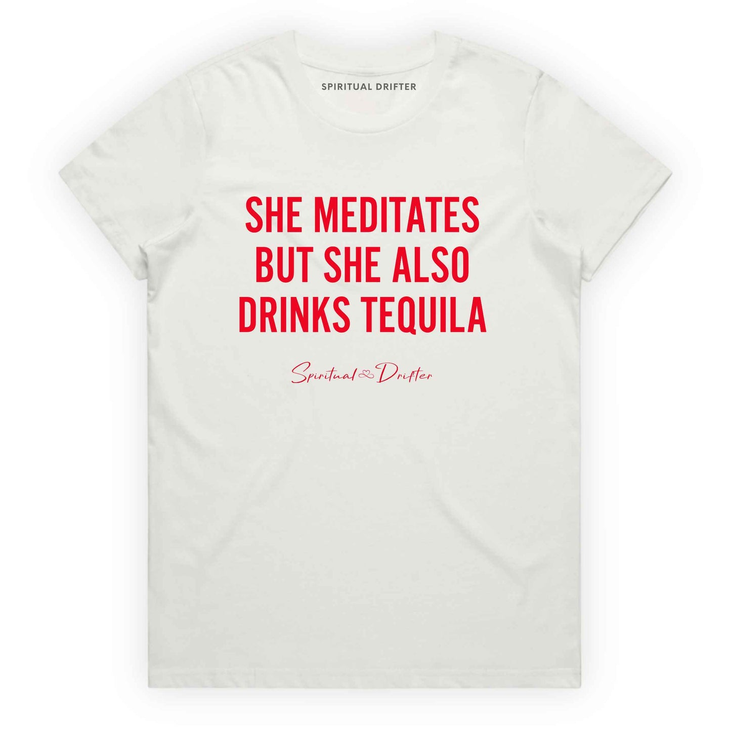 Natural Spiritual Drifter t-shirt with red text 'SHE MEDITATES BUT SHE ALSO DRINKS TEQUILA' on a white background. Women's spiritual graphic tee. Relaxed beach lifestyle fashion for meditation lovers, yoga enthusiasts, wellness travelers, and free-spirited women. Meditation and yoga clothing for awakened souls.