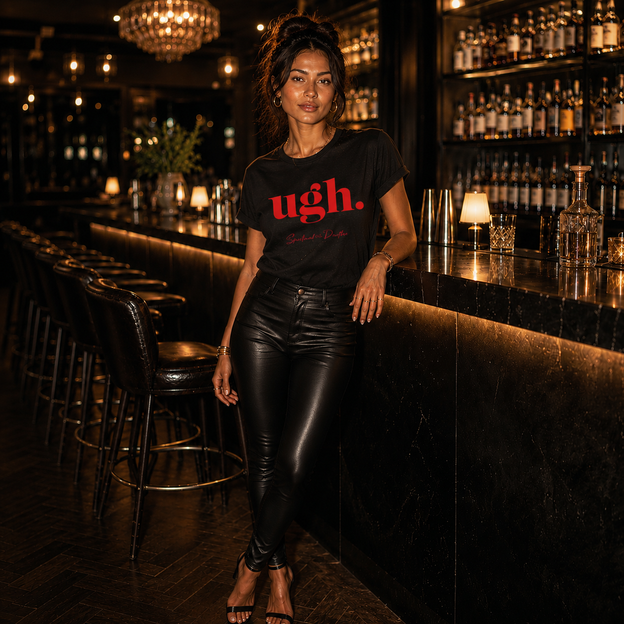 Woman in a bar wearing a black Spiritual Drifter t-shirt with red text 'ugh.' on a white background. Spiritual apparel inspired by modern mysticism, meditation, manifestation, sacred medicine and conscious living. Yoga and meditation clothing for awakened souls.