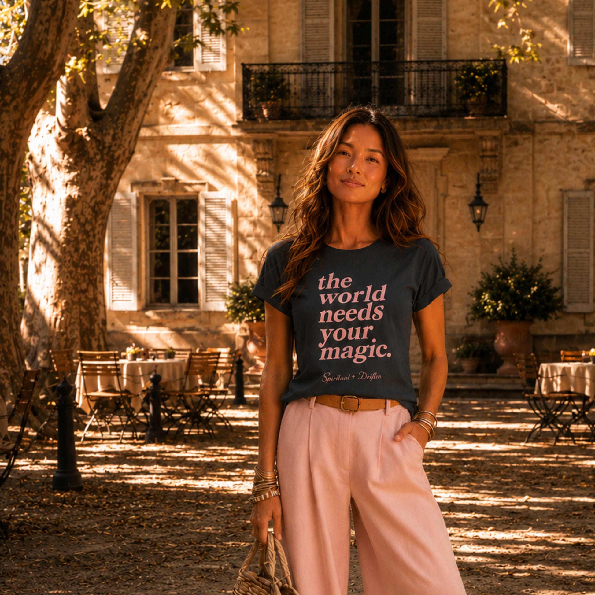 Woman wearing a Spiritual Drifter t-shirt with motivational "The world needs your magic" quote in an outdoor setting in Provence France.