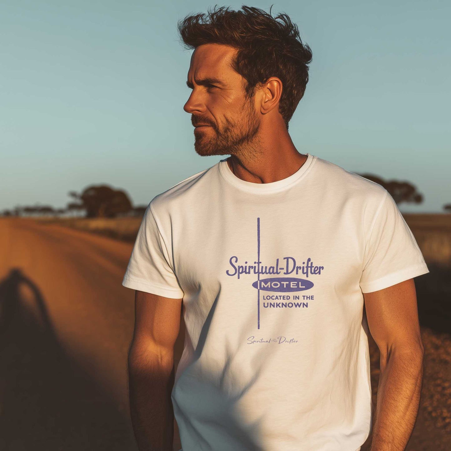 male model wearing white spiritual drifter motel located in the unknown unisex organic cotton t-shirt, vintage motel graphic tee, minimalist travel inspired clothing, outdoor lifestyle apparel