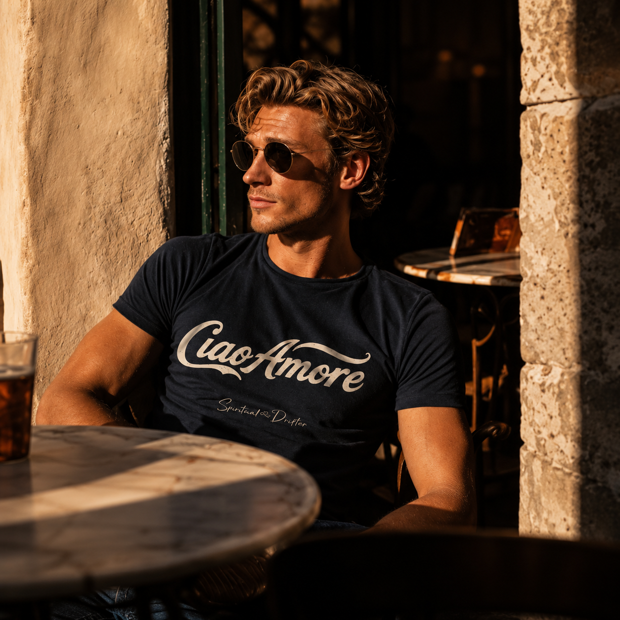 Man sitting at an outdoor cafe in Italy wearing a Spiritual Drifter  'Ciao Amore' t-shirt.